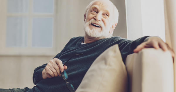 Older Man Relaxing On The Sofa At Home